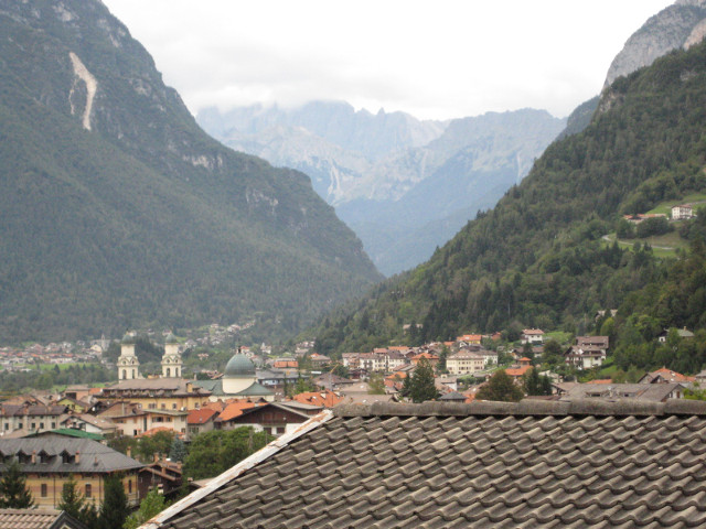 Panorama view up a deep alpine valley, town in centerground