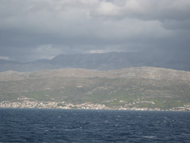 the mainland shore town backed by rocky ridges