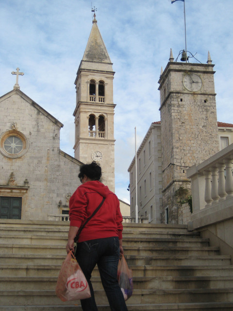 Venetian turf-marking woman climbing stone steps in front of Venetian bell-tower