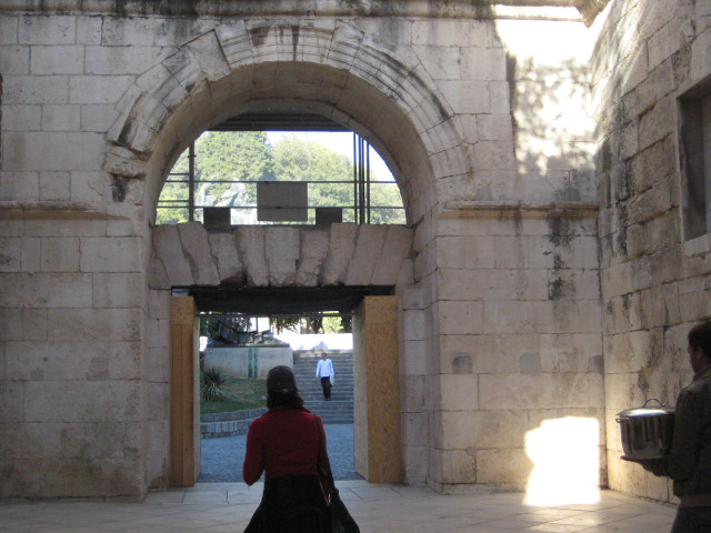 The Golden Gate statue visible through arched window over stone gate