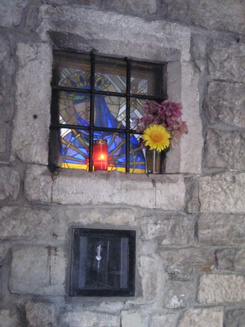 random corner in the maze stained glass window in white stone wall