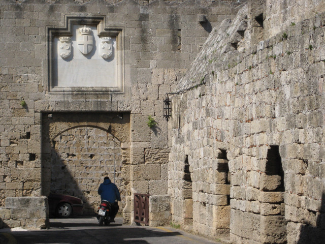 Scooter entering city Scooter in archway at end of stone bridge
