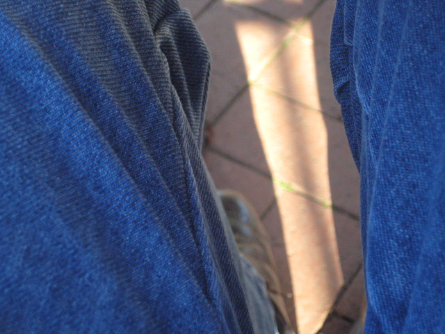 Jeans strip of sunlight on the ground between my jeans-
clad
kneew