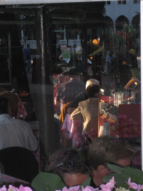 Last Light shaft of late sun on patrons in darkened bar / restaurant
