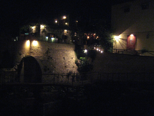 Past and Presence Night lights of a modern bar perched above an ancient ruin