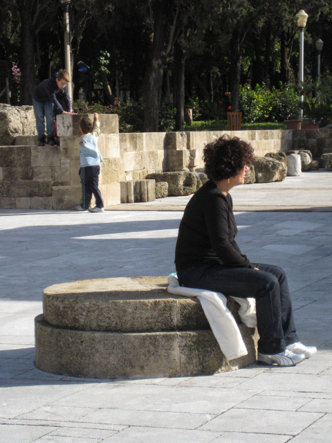 Resting the Feet Woman sitting on outdoor stone seat