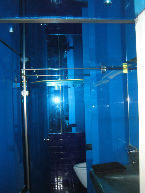 Mens room at wireless cafe deep blue walls, mirror ceiling, illuminated by flash