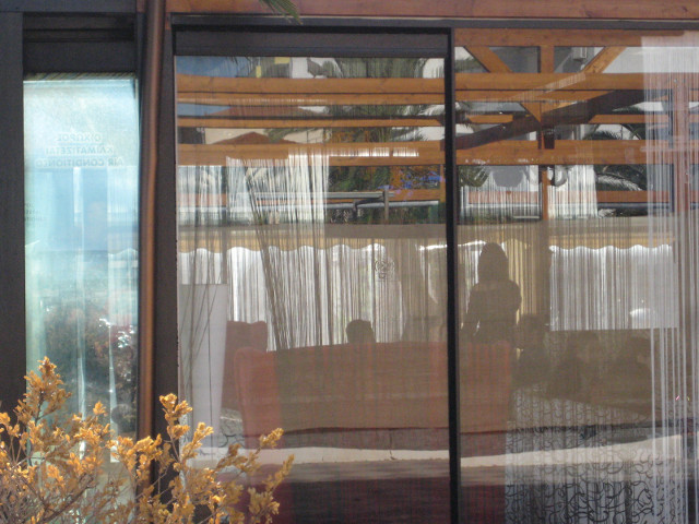 Outdoor annex silhouettes visible through thin curtains