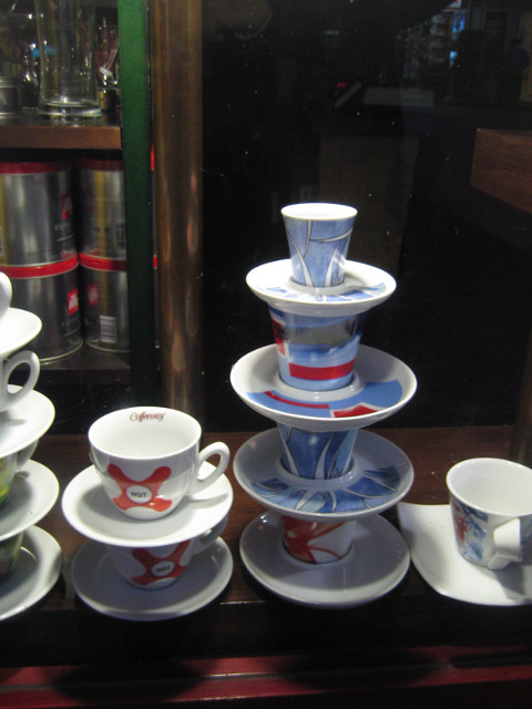 Climbing Saucers Stack of suacers and teacups in shop window at night