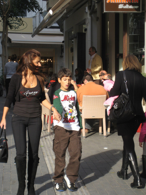 Mortification boy holding mother's hand on city street