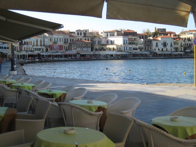 Venetian Harbor curving waterfront seen between cafe chairs and umbrellas