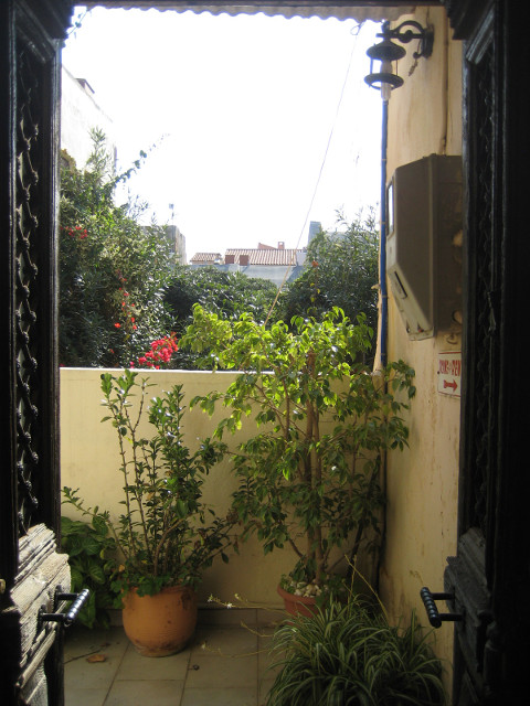 Heading Out old door wide open, vine-covered balcony