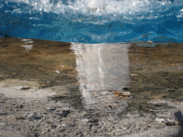 Fountain Rim reflectied fountain jet in puddle on rim