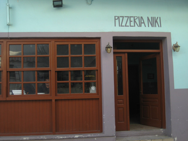 Pizzeria Niki Pastel blue pizzeria, sign over door