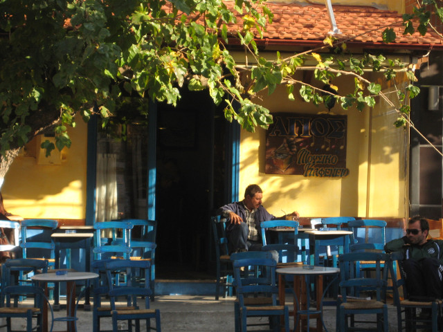 Ayios - Wireless Cafe yellow wall blue chairs, guitarist on porch