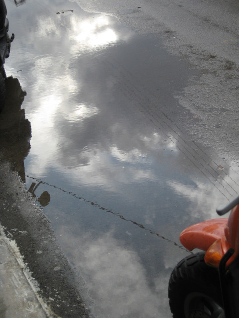 Street Puddle clouds reflected in puddle in street