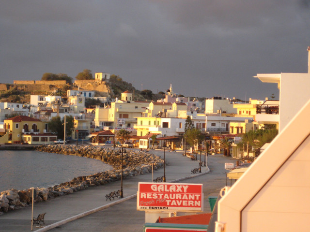 Inner Bay restaurant sign, sunlit houses, dark clouds