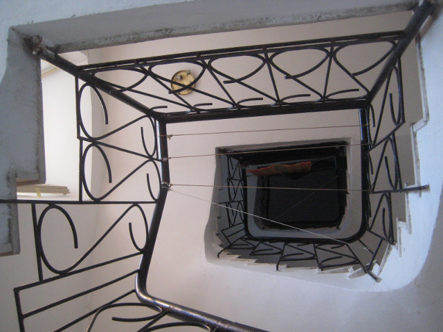 looking up white starwell with wrought-iron raling