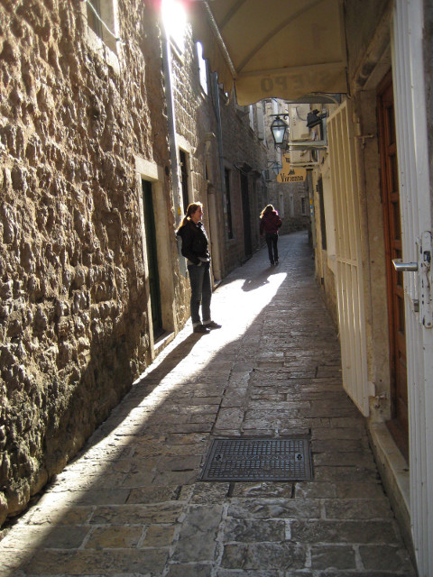 old city street sunlit alleyway with a couple of people