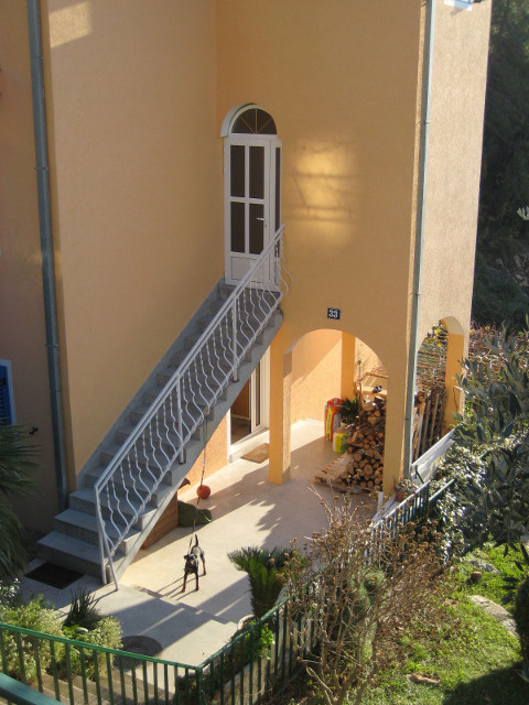 Bored Pooch. Sveti Stefan, Montenegro lookking down into yard with dog