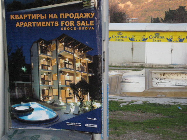 condos 'n beer corona beer sign behind real estate placard