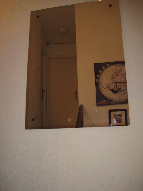 bedroom door ahead staris, mirror showing a door
