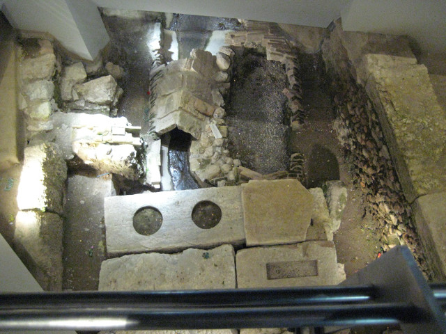 subterranean display at metro station Miscellaneous stone blocks at the bottom of a shallow shaft