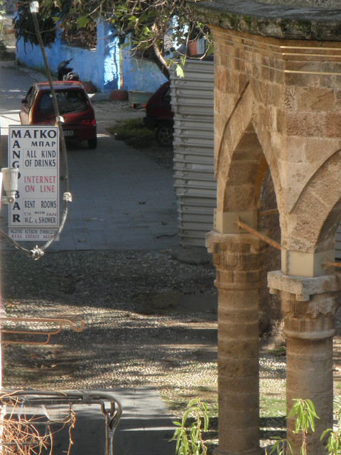 Mango Bar sign for Mango Bar, edge of pointy-arched footwashery, distant blue wall