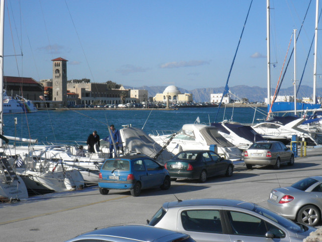 Mandhraki Harbor old-ish buildings across yacht harbor