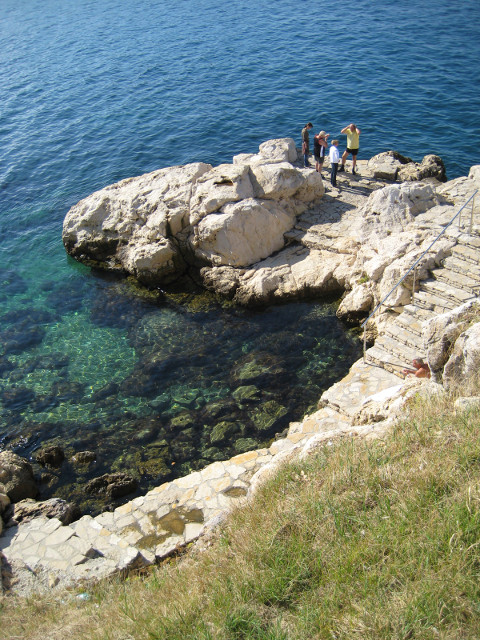 Rovinj Rocky Point Limestone spit in clear shallow waters