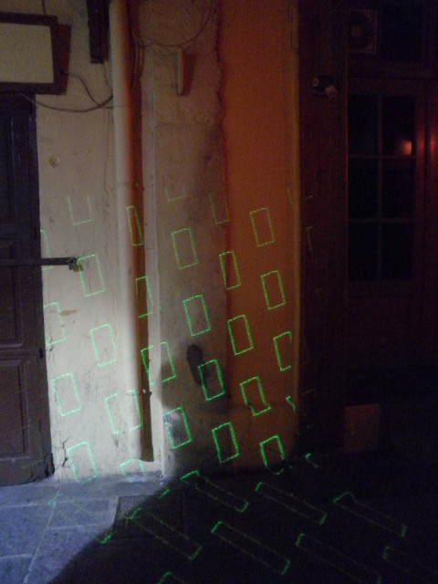 Disco Nearby green laser rectangle outlines on wall in narrow street