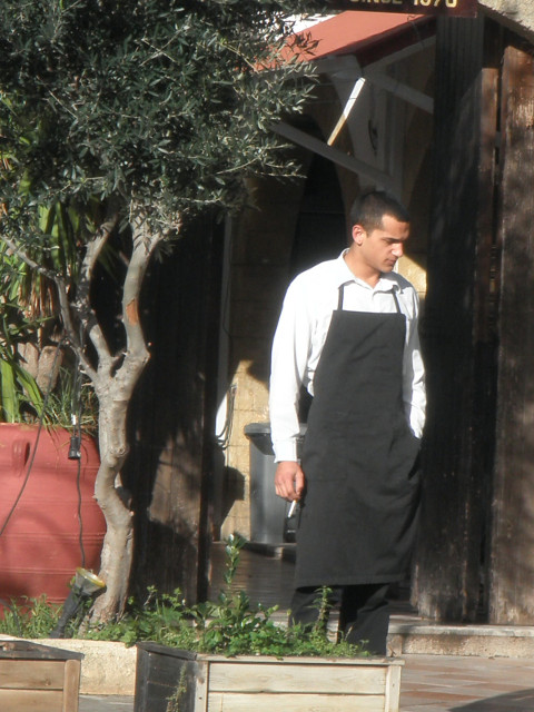 Off Season Restaurateur waiter stannding in doorway lookingg frustrated