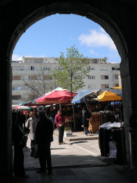 through some gate umbrellas for market stands, framed by gate