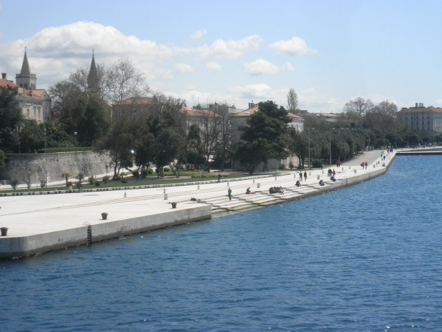 shoreline with sea organ sea lined with concrete walkway and steps