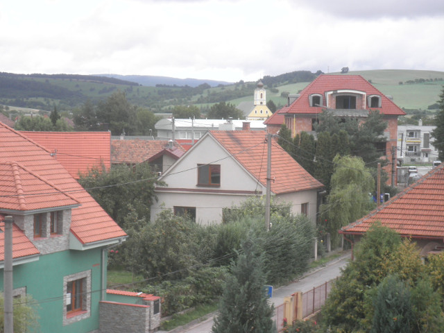 northward view village houses, peaked red tile roofs, small church