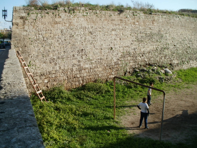 Makeshift football field kids with ladder in the medieval moat