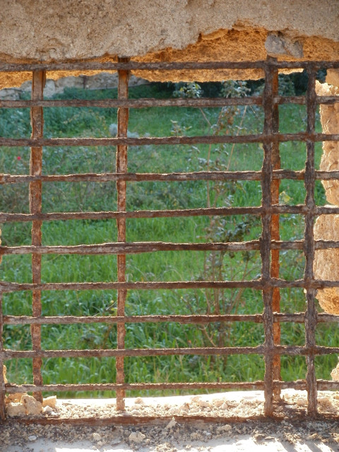Moat Grass default alt textAn old iron grill on a window into the moat